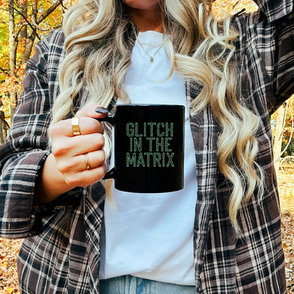 11oz ceramic mug featuring 'Glitch in the Matrix' text, inspired by simulation theory and digital aesthetics.