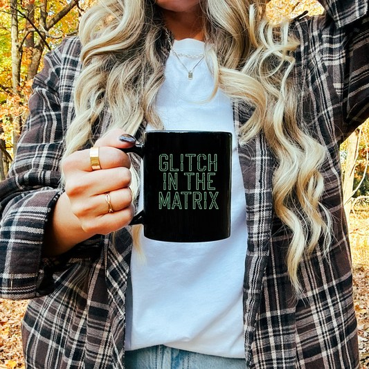 11oz ceramic mug featuring 'Glitch in the Matrix' text, inspired by simulation theory and digital aesthetics.