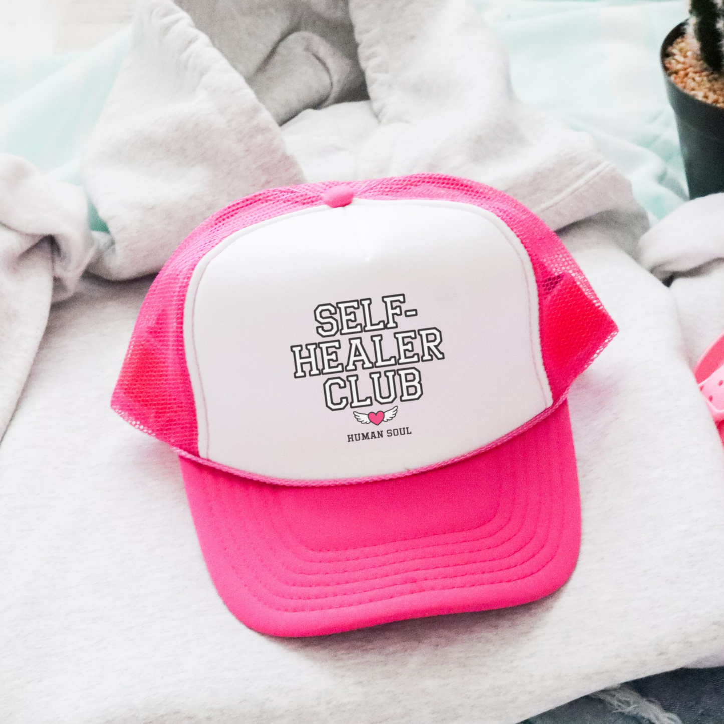 Self Healer Club pink mesh trucker hat, a stylish cap for wellness enthusiasts and energy healers.